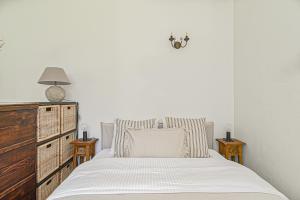 1 dormitorio blanco con 1 cama y vestidor en Cozy Studio in the heart of Vilnius Old Town, en Vilna