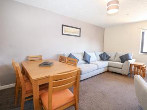uma sala de estar com uma mesa e um sofá em Flat 34 - Marine Court em Littlehampton