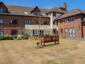 um banco num quintal em frente a um edifício em Flat 34 - Marine Court em Littlehampton