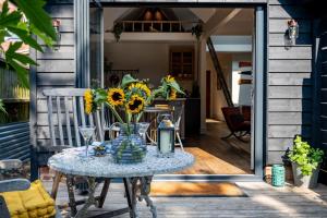 een tafel met een vaas met zonnebloemen op een patio bij The Little Gate House in Milford on Sea