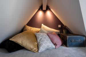 een stapel kussens op een bed op zolder bij The Little Gate House in Milford on Sea