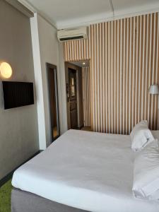 un grande letto bianco in una camera d'albergo di Hôtel La Villa Tosca a Cannes