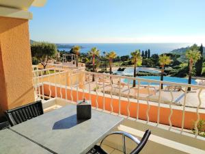 a balcony with a table and a view of the ocean at Village Cap Estérel Agay St Raphaël vue mer et piscine in Agay - Saint Raphael