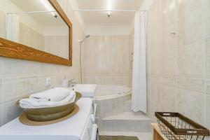 Un baño con lavabo, bañera y espejo. en Cozy Studio in the heart of Vilnius Old Town, en Vilna