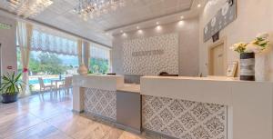 a lobby with a counter and a table with chairs at Kamenec Hotel in Nesebar