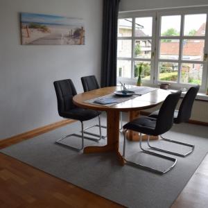 ein Esszimmer mit einem Holztisch und schwarzen Stühlen in der Unterkunft Finke-Ferienhaus - OG in Grömitz