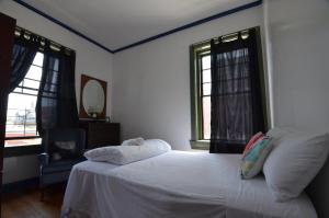 a bedroom with a white bed and two windows at Amazing 3 Bedroom Apt! 11 Beds! in Providence