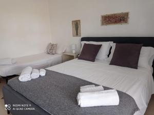 two beds in a room with towels on them at La riva in Noto Marina