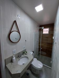 y baño con lavabo, aseo y espejo. en Pousada Vila Praiana, en Arraial do Cabo