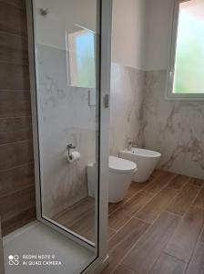 a bathroom with a toilet and a glass shower at La riva in Noto Marina