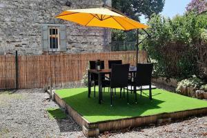 une table et des chaises sur une parcelle d'herbe avec un parasol dans l'établissement Maison chaleureuse avec exterieur près de la ville, à Lafox