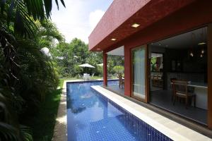 Casa Temporada - 4 suítes - Condomínio Luxo - Piscina Extraordinária - Praia de Itacimirim-BA في كامساري: مسبح بجانب منزل