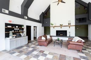 a living room with two chairs and a fireplace at Carolina Pine Inn near Southern Pines-Pinehurst in Pinebluff