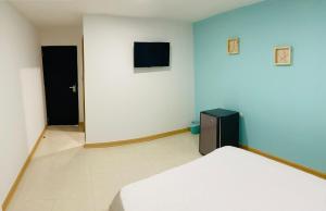 a bedroom with a bed and a tv on the wall at Casa Arena San Andres in San Andrés