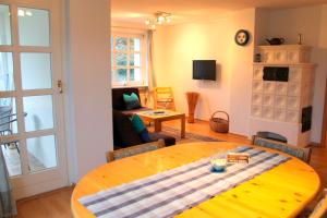 Zimmer mit einem Holztisch und einem Wohnzimmer in der Unterkunft Finke-Ferienhaus - OG in Grömitz