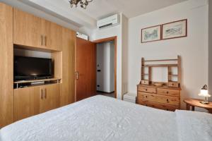 a bedroom with a bed and a flat screen tv at Moleloca - San Tommaso Apartment in Turin