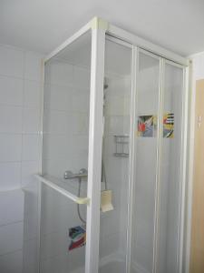 um chuveiro com uma porta de vidro na casa de banho em Dachgeschoss Feriewohnung für Zwei em Colônia