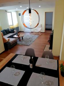 un soggiorno con 2 tavoli e bicchieri da vino di NIKAS Apartman a Donji Milanovac