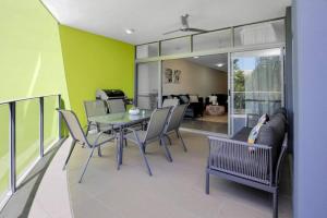 comedor con mesa y sillas en Pool View City Centre Apartment 202 en Cairns