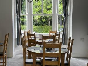 jadalnia ze stołem i krzesłami oraz oknem w obiekcie Lantana Guest House w mieście Weymouth