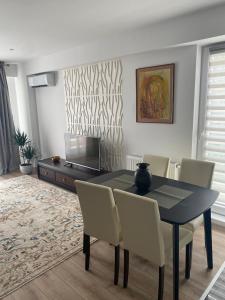 uma sala de jantar com uma mesa preta e cadeiras em Bucharest Airport Suites & Villas em Otopeni