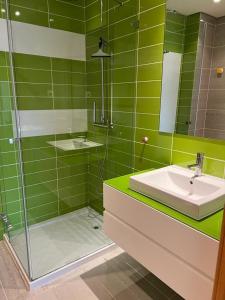 een groene badkamer met een wastafel en een douche bij Amazing View With Pool in Albufeira