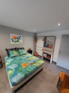 a bedroom with a large bed with a tropical print at BLUE DREAM SPA in Les Trois-Îlets