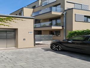 une voiture noire garée devant un immeuble dans l'établissement Cityappartement am Goethepark, à Weimar