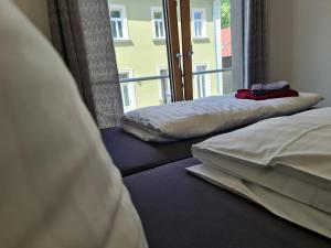 deux lits assis dans une pièce avec une fenêtre dans l'établissement Cityappartement am Goethepark, à Weimar
