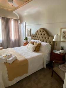 een slaapkamer met een groot bed en een stoel bij Augusta Guest House in Augusta