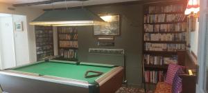 a room with a pool table in a library at The Poplars Guest House in Combe Martin