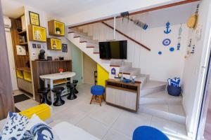 a living room with a staircase and a room with a table at Flat Solar Água 127 - Family & Friends in Pipa