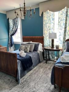 Augusta Guest House في Augusta: غرفة نوم بجدران زرقاء وسرير وطاولة