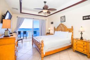 a bedroom with a bed and a view of the ocean at Del Playa Penthouse #5 Condo in West End