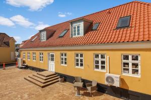 un edificio amarillo con techo rojo en Skudehandelen., en Lønstrup