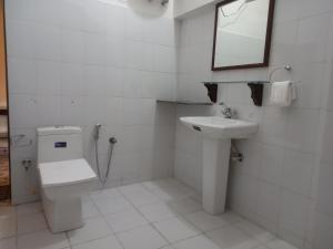 a bathroom with a toilet and a sink and a mirror at Sankhu Niwas in Bikaner
