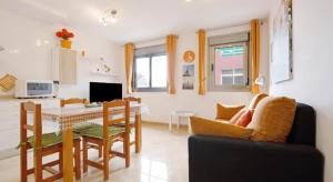 a kitchen and living room with a table and chairs at APARTMENT ORANGE FUERTEVENTURA in Puerto del Rosario