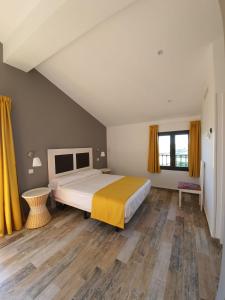 1 dormitorio con 1 cama grande y suelo de madera en Finca La Calancha, en Cuerva