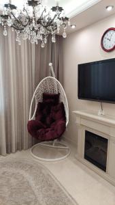 a hanging chair in a living room with a tv at Квартира посуточно в Соломенском районе in Kyiv