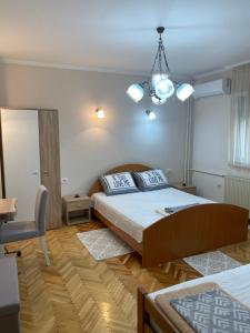 a bedroom with a bed and a chandelier at Apartment "JONA " in Niš