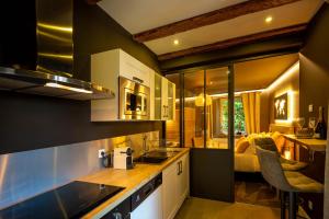 a kitchen with a sink and a room with a bed at La Suite - Spa & Sauna in Kaysersberg +13 photos