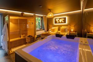 a large bathroom with a tub and a bedroom at La Suite - Spa & Sauna in Kaysersberg