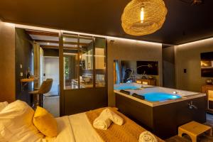 a bathroom with a tub and a sink and a bed at La Suite - Spa & Sauna in Kaysersberg