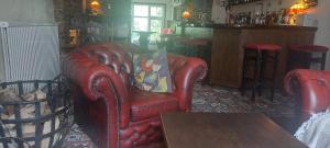 a living room with a red leather chair and a table at The Poplars Guest House in Combe Martin