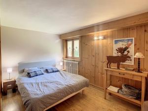 a bedroom with a bed and a wooden wall at Appartement Combloux, 3 pièces, 5 personnes - FR-1-560-27 in Combloux