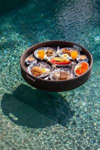 ein Tablett mit Essen im Wasser in einem Pool in der Unterkunft Villa Markisa Echo Beach in Canggu