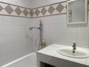 La salle de bains blanche est pourvue d'un lavabo et d'une baignoire. dans l'établissement Le pigeonnier de Saint-Loup Bed and Breakfast, à Saint-Loup-de-Varenne