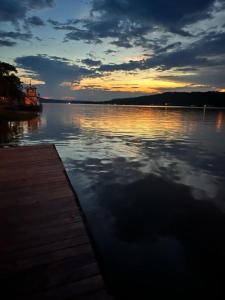 a sunset over a body of water with a wooden dock at Augusta Guest House in Augusta