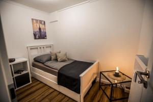 een kleine slaapkamer met een bed en een tafel bij Exklusive Neubau Wohnung im Luftkurort Buchholz in Buchholz in der Nordheide