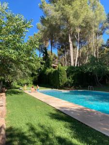 una piscina en un patio con gente a su alrededor en Acogedor chalet familiar en la Sierra Calderona, en Nàquera